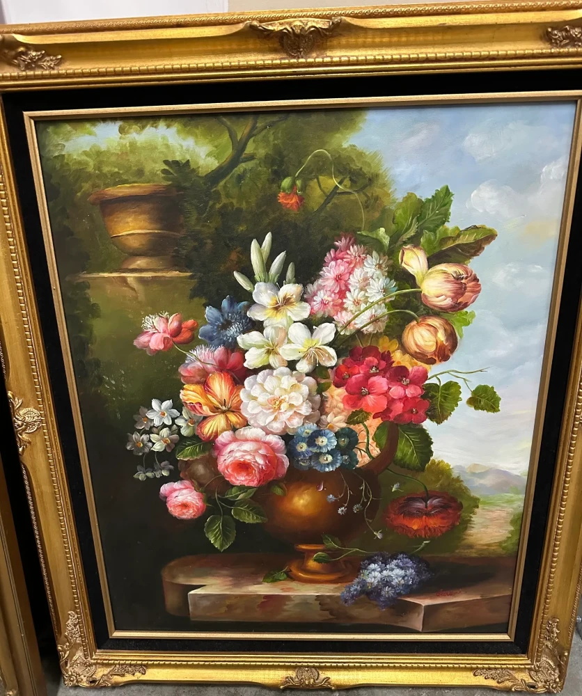 Traditional framed floral still life featuring a full bouquet of colorful flowers in a dark vase.